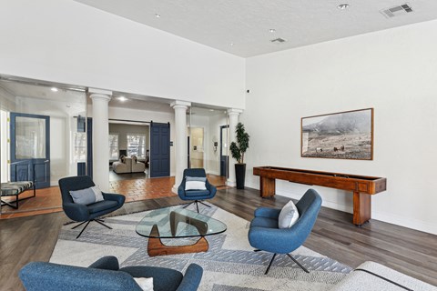 A living room with blue chairs and a wooden bench.
